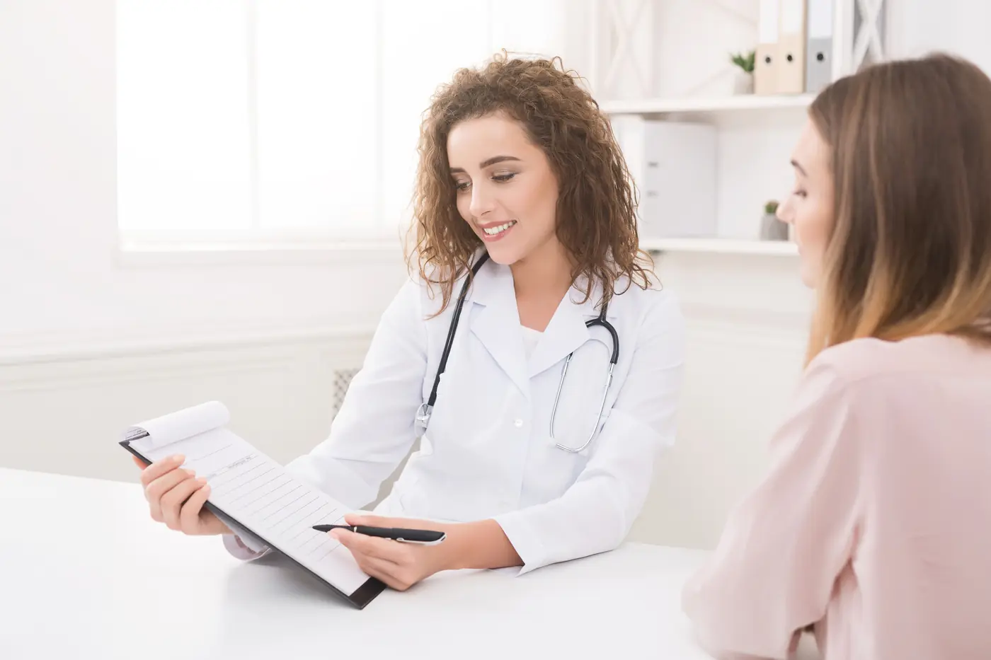Doctora conversando con una paciente en su consultorio
