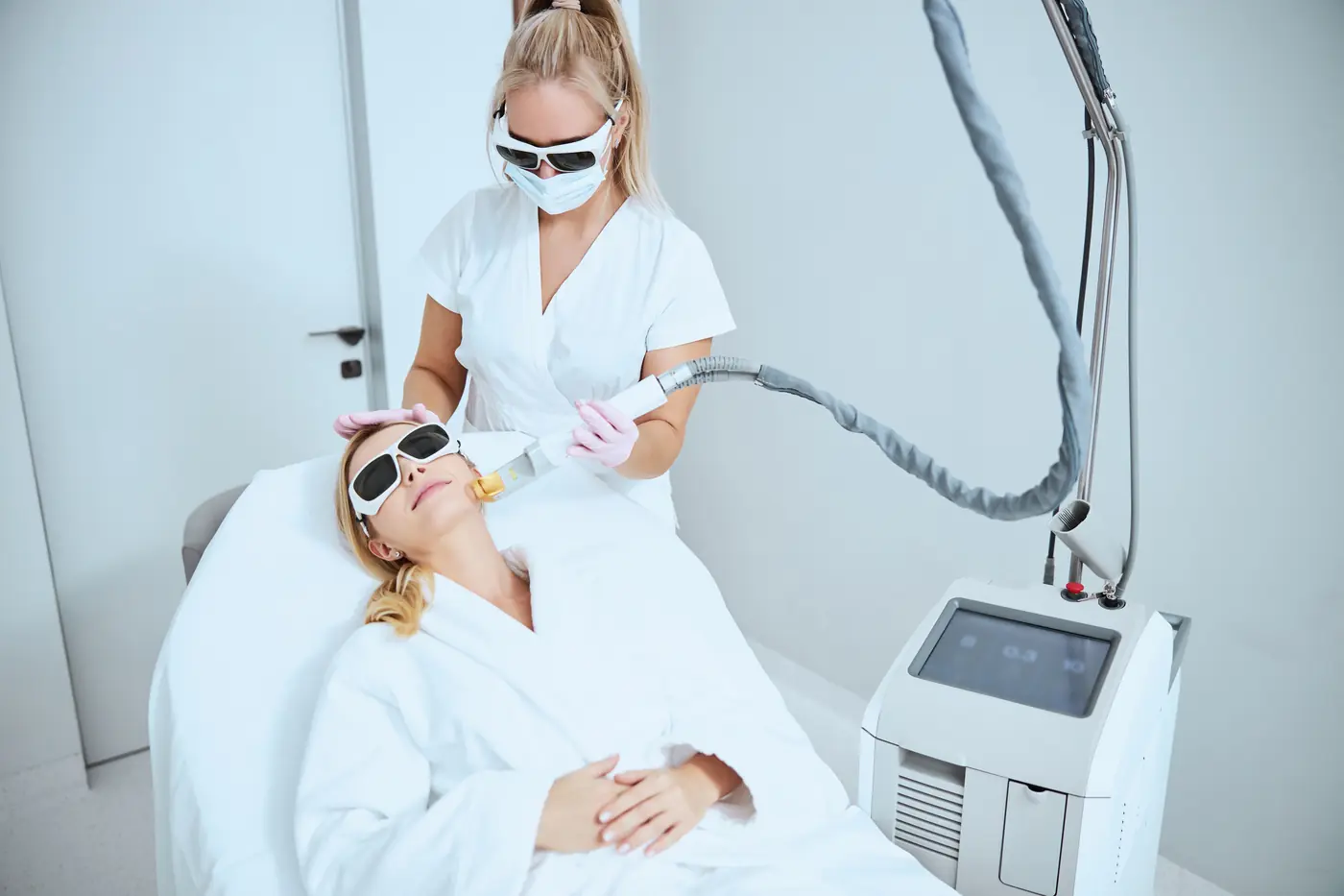Dermatóloga realizando un tratamiento láser facial