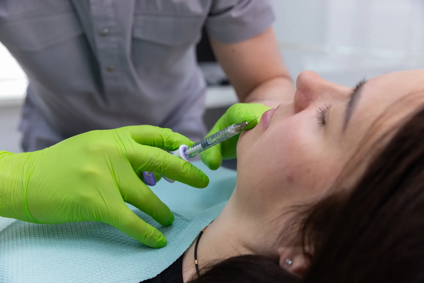 Professional applying lip filler in a modern practice