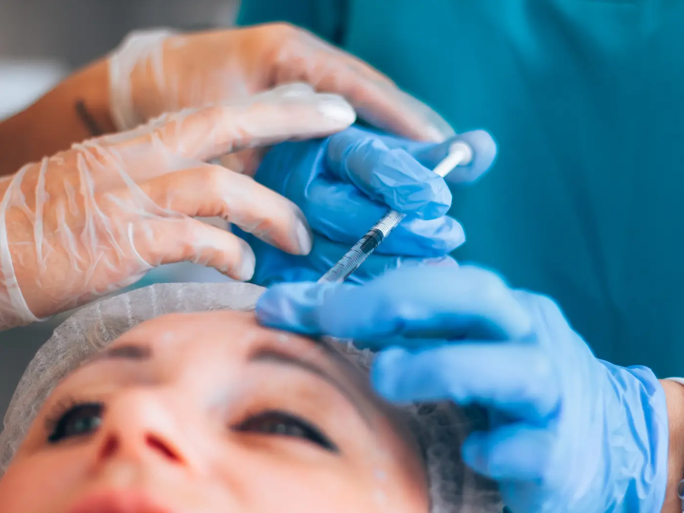 Médica aplicando un tratamiento inyectable con acompañamiento de una colega