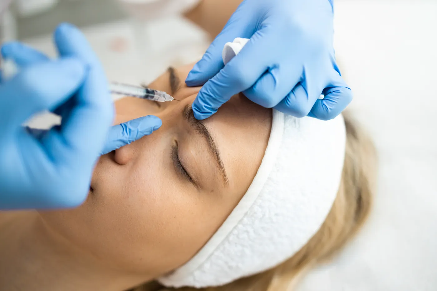 Professional injecting botulinum toxin into a patient's glabella